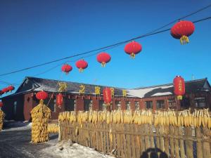a group of red and yellow lanterns hanging over a fence at Wusong Island Wusong Country House in Jilin