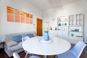 a white living room with a white table and blue chairs at Relax in Riva by MONHOLIDAY in Monopoli