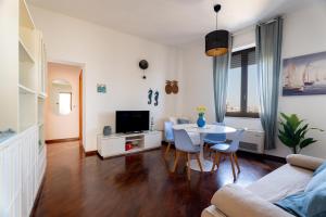 a living room with a table and a tv at Relax in Riva by MONHOLIDAY in Monopoli