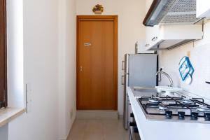 a kitchen with a stove and a brown door at Relax in Riva by MONHOLIDAY in Monopoli +20 photos
