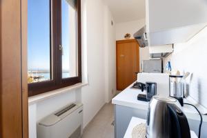a small kitchen with a window and a coffee maker at Relax in Riva by MONHOLIDAY in Monopoli