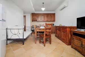 a kitchen with wooden cabinets and a table and chairs at Bella Vista su tavolara 4 in Porto San Paolo