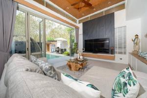 a living room with a couch and a flat screen tv at Wila villas Phuket Free Airoport Pick up from 7 days in Phuket