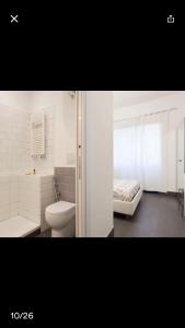 ローマにあるCharming Apartment Near Sant Peter Squareの白いバスルーム(トイレ付)、ベッド1台が備わります。