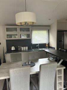 a kitchen with a table and chairs and a kitchen with a sink at Poppy in Ferndown