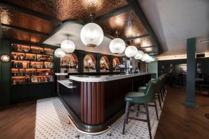 a bar in a restaurant with green chairs and lights at Nuremore Estate in Carrickmacross