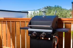 a grill sitting on a wooden fence at Rose Diamond Villa - cosy, large, family mobile home, free wifi and parking in Pakoštane