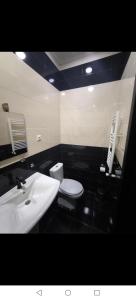 a bathroom with a white toilet and a sink at Diuma 5 Guest house in Tbilisi City +48 photos