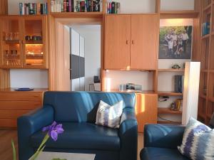 a living room with a blue couch and wooden cabinets at Ferienwohnung RoSi in Ebermannstadt +24 photos