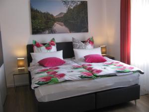 a bedroom with a bed with pink and white pillows at Ferienwohnung RoSi in Ebermannstadt