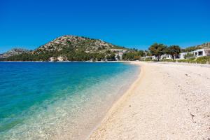 a beach with blue water and a mountain in the background at Rose Diamond Villa - cosy, large, family mobile home, free wifi and parking in Pakoštane +22 photos