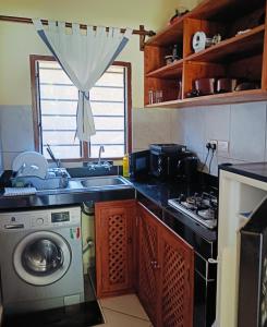 a kitchen with a washing machine and a sink at Summer Studio Suit in Malindi
