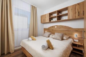 a bedroom with a bed with two pillows on it at Rose Diamond Villa - cosy, large, family mobile home, free wifi and parking in Pakoštane