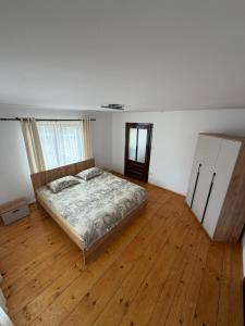 a bedroom with a bed and a wooden floor at Casa Pietrele Doamnei in Câmpulung Moldovenesc