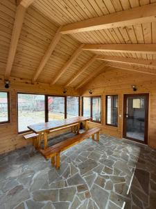 a large wooden room with a bench on a stone floor at Casa Pietrele Doamnei in Câmpulung Moldovenesc