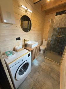 a bathroom with a washing machine and a toilet at Domki Pod Stromcem in Czernica +65 photos