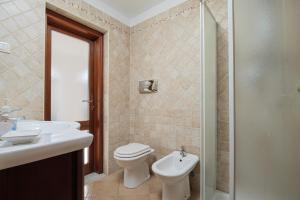 a bathroom with a toilet and a sink and a shower at Bella Vista su tavolara 5 in Porto San Paolo +13 photos