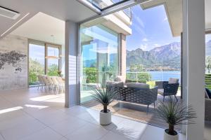 a living room with a view of the water and mountains at Villa Costanza- private heated pool, steam room & sauna - Bellagio Village Residence in Oliveto Lario