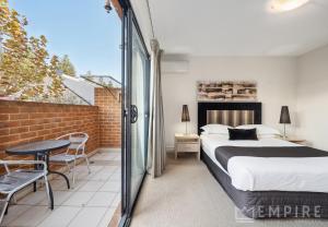 a bedroom with a bed and a balcony at Parklane Apartments in Fremantle
