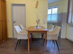 a dining room with a wooden table and chairs at Waldliebe Spiegelhütte - Ferienwohnung am Bach in Lindberg