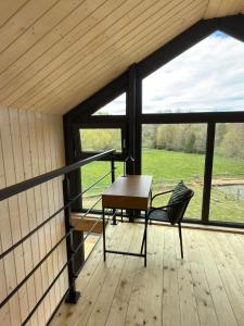 a room with a table and a chair on a wooden floor at Domki Pod Stromcem in Czernica