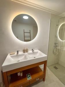 a bathroom with a white sink and a mirror at Refúgio dos Arrifes in Vila Baleira +11 photos