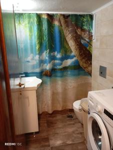 a bathroom with a palm tree mural on the wall at Summer apartment in Nea Peramos
