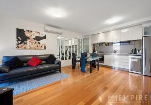 a living room with a black couch and a table at Parklane Apartments in Fremantle
