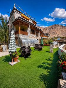 a building with a yard with green grass at Teyser Holiday Home in Leh