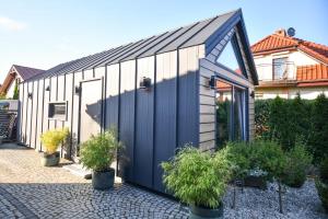 a black and white building with potted plants at Domek Klara in Wałbrzych