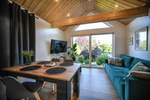 a living room with a wooden table and a blue couch at Domek Klara in Wałbrzych +9 photos