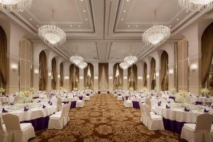 a banquet hall with white tables and chairs and chandeliers at Yinrun Jinjiang Castle Hotel in Anji