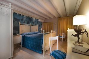 a bedroom with a bed with a blue comforter at Boutique Hotel Villa dei Campi in Gavardo