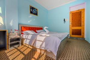 a bedroom with a large bed with white sheets at hotel the kannaz in Srinagar