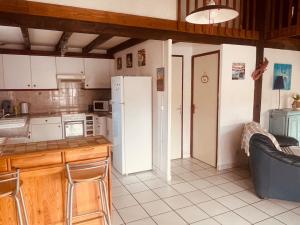 a kitchen with a refrigerator and a table and chairs at L'Ancre Marine in Valras-Plage +8 photos