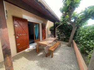 a wooden bench sitting outside of a house at L'Ancre Marine in Valras-Plage