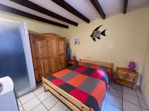 a bedroom with a bed with a colorful comforter at L'Ancre Marine in Valras-Plage