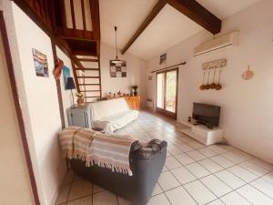 a living room with a couch and a tv at L'Ancre Marine in Valras-Plage