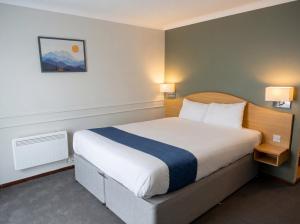 a bedroom with a large bed in a hotel room at Days Inn Hotel Leicester in Leicester