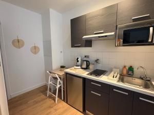 a small kitchen with a sink and a counter at Coudert l Petit studio côté rue l Rez-de-chaussée en Hypercentre & climatisé in Castres