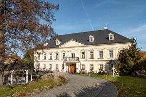 a large white house with a black roof at Zámeček Petrovice u Karviné in Petrovice u Karviné