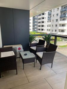 a patio with chairs and tables and a large window at Suite Luxury Pipera and Spa in Bucharest