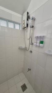 a white bathroom with a shower and a sink at ClubBoracay Apartelle in Boracay +81 photos