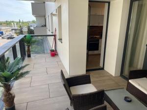 a balcony with a table and chairs and a kitchen at Suite Luxury Pipera and Spa in Bucharest +2 photos