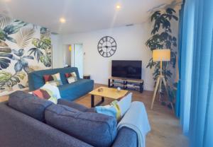 a living room with a blue couch and a table at la Pascaline in Saint-Clément-de-Rivière
