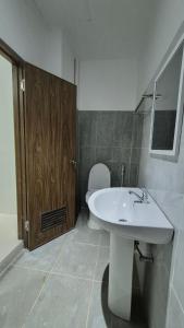 a bathroom with a white sink and a toilet at Beachfront White House for 10pax in Caba