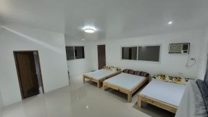 a room with two beds and chairs in it at Beachfront White House for 10pax in Caba