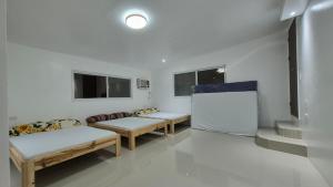 a room with three benches and a couch and windows at Beachfront White House for 10pax in Caba