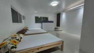 two beds in a room with white walls at Beachfront White House for 10pax in Caba