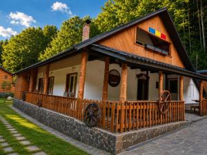 a log cabin with a porch and a window at Cabana Tarța din Blidari 1 in Baia Mare